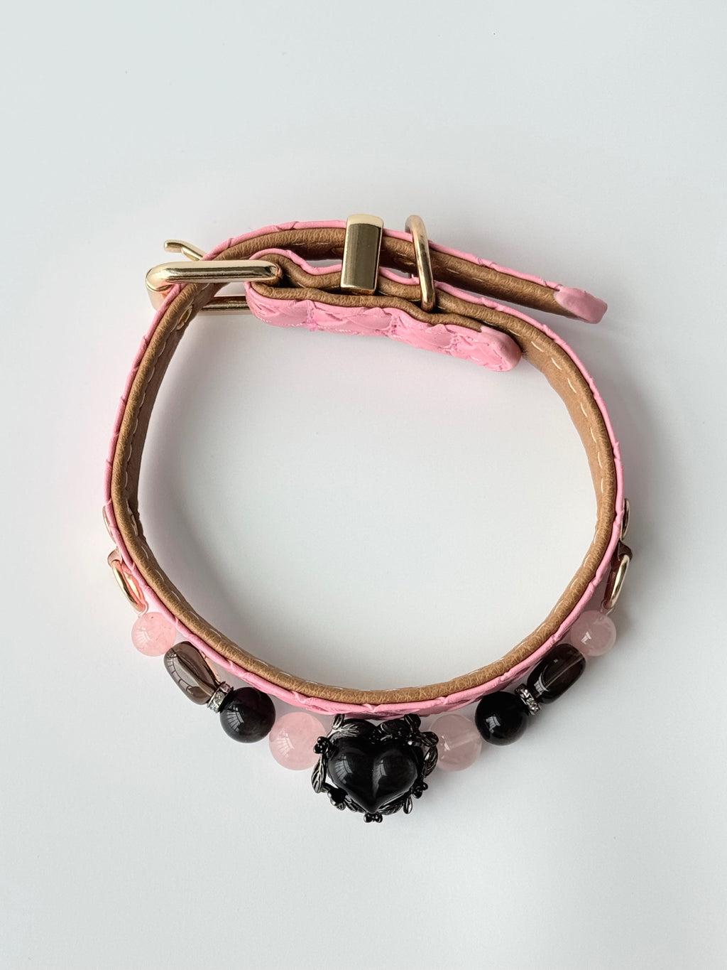 cat wearing pink woven leather collar with black obsidian heart charm