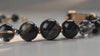 Close-up shot of a luxury pet collar featuring a natural polished Obsidian gemstone, with soft lighting highlighting its authentic deep black texture and elegant sheen.